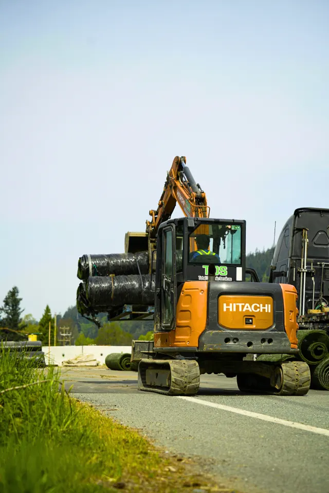 TDS Civil excavator carrying drainage pipe on a Lower Mainland roadside work site